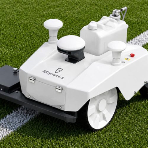 Autonomous GPS sports field line-marking robot painting a precise white boundary line on green grass.